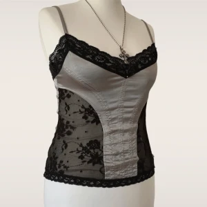 Topp i silver och svart med spets! - Supersnygg! Använd fåtal ggr och har tyvärr ett litet hål i spetsen (se sista bilden). Passar S-M ❤️OBS! Det är inte fri frakt på denna annons, plick har lagt dit det automatiskt!