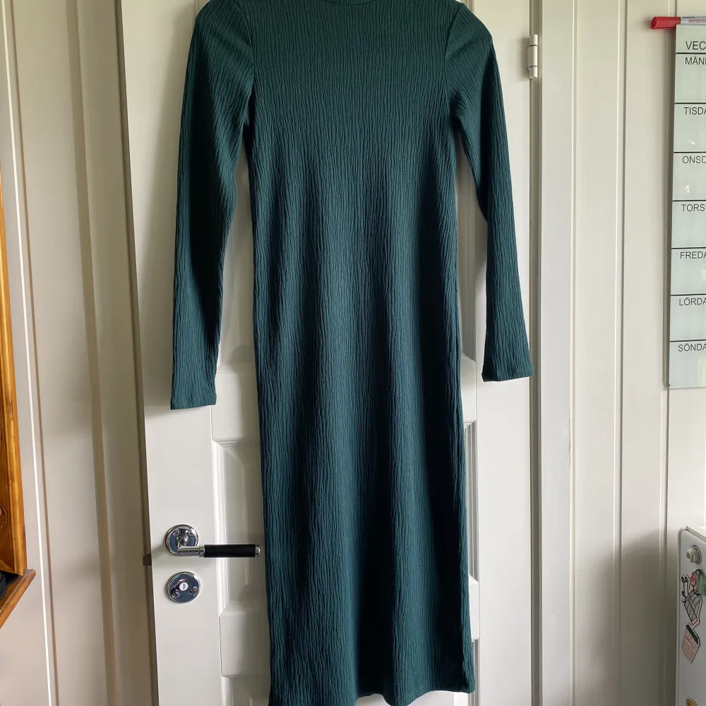 Lång mörkgrön klänning från Lindex strl XS, men den är stretchig i tyget så passar någon med S även. Använd ett fåtal gånger. . Klänningar.