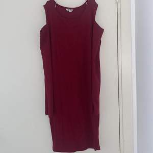 En vinröd ribbad klänning från Cubus i storlek 158/164. 