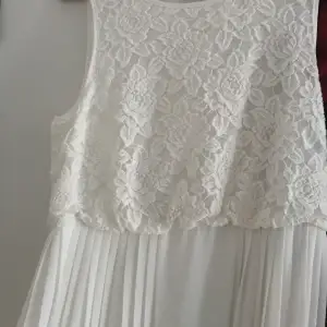 Vit långklänning  Säljer denna söta klänning som bara hänger  oanvänd här! Underbar plisserad kjol med vita blommor i mönstret upptill ♥️ storlek 38 ♥️ passar till fest men funkar nog till bröllop också ♥️😍🥰