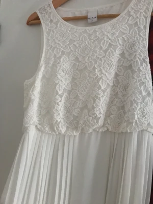 Vit långklänning ♥️ - Vit långklänning  Säljer denna söta klänning som bara hänger  oanvänd här! Underbar plisserad kjol med vita blommor i mönstret upptill ♥️ storlek 38 ♥️ passar till fest men funkar nog till bröllop också ♥️😍🥰