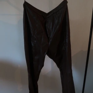 Bruna skinnbyxor - Dessa bruna skinnbyxor kommer från märket Collusion. Lite utsvängda i modellen. Bra kvalitet och endast använda en gång. Jag är 167 lång och dessa byxor går ner till mina fötter. 