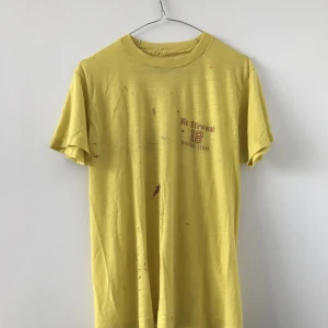 Gul vintage tee - Säljer en gul vintage tee med tryck. Använd men har fortfarande liv kvar i sig, från 70-talet.