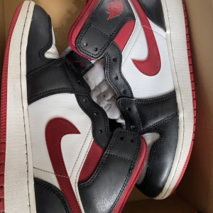 Jordan 1 mid gym red (gs) - Jordan 1 mid gym red bra skicka box följer med boxen har en vatten skada i botten som är liten. Skorna är i bra skick har inte blivit använda mycket.