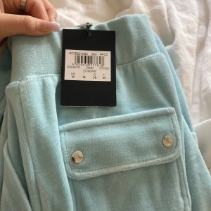 JUICY COUTURE BLÅ/TURKOS - Ett par ljus blå/turkosa juicy byxor i strl M, använt en gång men kom tyvärr inte till användning efter dess. De är i helt nytt skick kom privat för fler bilder och pris diskutering. Köpt från juicy coutures hemsida och köpare står för frakt.
