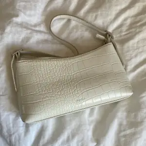 Säljer nu denna stilrena vita väskan från na-kd. (Säljer även jackan🤗) Super trevligt till sommaren med en ljus väska. Längd ca 26cm, höjd ca 14cm. Banden är justerbara. Nypris ca 400kr, pris går att diskutera.🌇💫
