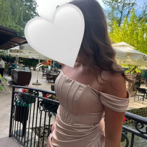 Festklänning  - Säljer denna fina beige/guldiga festklänning/balklänning, endast använd vid ett tillfälle🤍 klänning med korsett & volanger off shoulder 🤍 Klänningen är i storlek 38/40 passar även 42. 