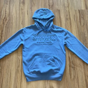stranger things hoodie - Ljus blå stranger things hoodie som gjordes av netflix