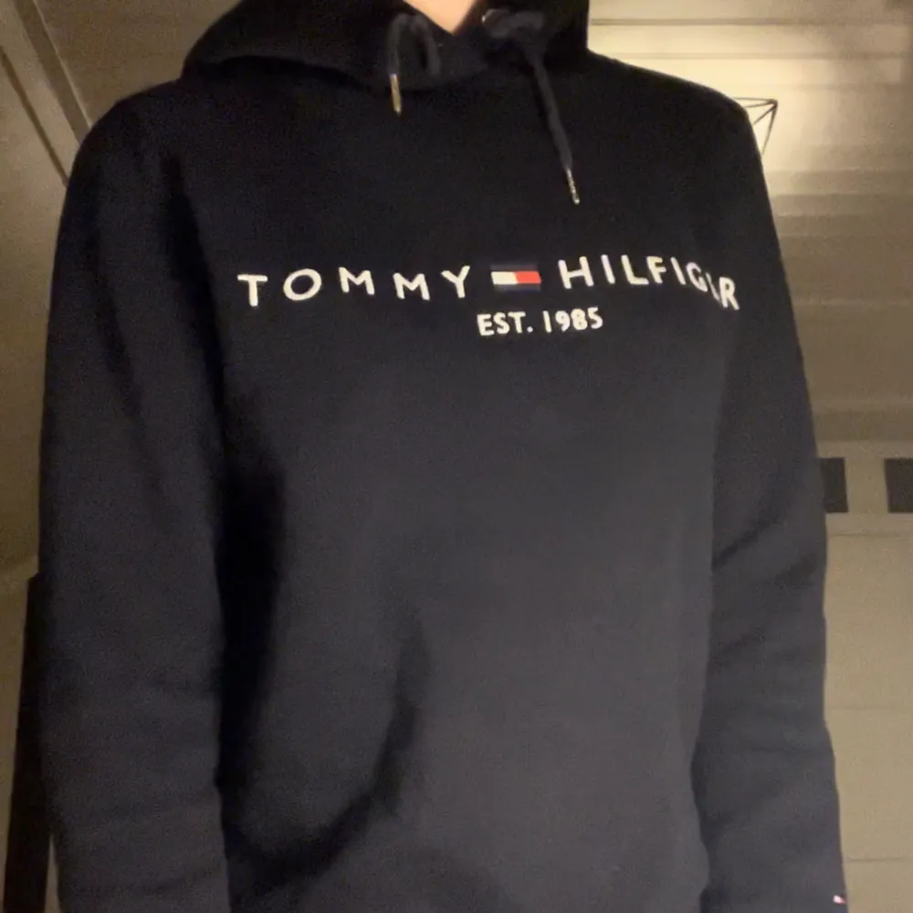 Säljer denna superfina marinblåa hoodien från Tommy Hilfiger. Väldigt bekväm på och i bra kvalité. Använd ett fåtal gånger. Säljes pga kommer ej till användning. Fler bilder kan fås vid förfrågan🥰. Hoodies.