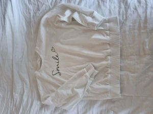 Tröja - Vit tröja med texten Smile fram. Oanvänd. Cotton 79% Elastane 4% Polyester 17% EU 152 US 11-12Y