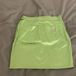 Grön Moschino kjol strl S💚 - En grön Moschino kjol med ett silver peace tecken på bakfickan! Vintage men bra skick.