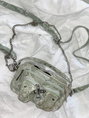 Núnoo väska - Núnoo väska i sneak print, både kedjan och axelremmen går att ta av, 4 fack👌🏼🐍🤍 Nypris 1300