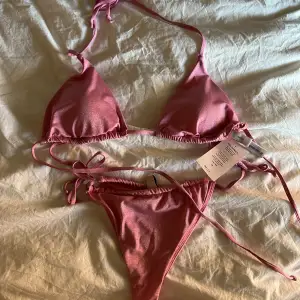 Helt oanvänd skitsnygg rosa glittrig bikini, topp storlek M underdel storlek L. Prislappar kvar 
