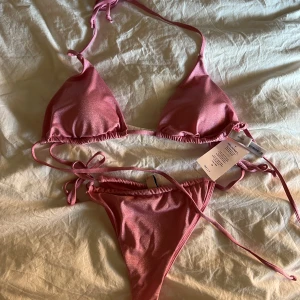 Glittrig rosa bikini  - Helt oanvänd skitsnygg rosa glittrig bikini, topp storlek M underdel storlek L. Prislappar kvar 