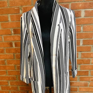 Superfin dam kavaj från New Yorker - Superfin öppen dam kavaj från New Yorker i svart/vit randigt tryck.  Storlek 40/L (men sitter som 38/M).  Kavajen har 2 fram fickor.  Butikspris 289 kr.  Helt ny och ej använd med orginal etikett kvar. 