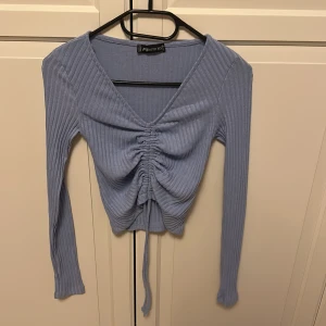 Baby blå v ringad tröja - En super snygg tröja med snören. Storlek Xxs från New Yorker. 