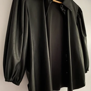 Tunn skinnjacka med krage och puffärmar - En svart och tunn skinnjacka med knappar. Köpt ifrån Design Only (D.O.). Använt den en gång och kände inte att det var något jag skulle bära på. Väldigt bra att ha till vår, sommar och även höst. Går att också använda den som kavaj. Precis som ny🖤