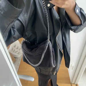 Stella McCartney inspirerad väska - Svart Stella McCartney inspirerad väska i bra skick, den enda defekten är att ena delen av knappen gått av som ni kan se på sista bilden (dock inget som syns eftersom det är inuti väskan)