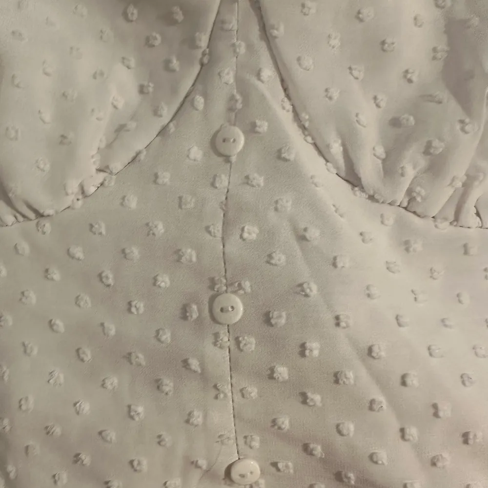Säljer min fina vita somriga topp. Ärmarna är väldigt luftiga och är i ett mycket tunt material, med fina detaljer på. Toppen är figursydd vid bysten, se bild 2. Knapparna går ej att öppna 💕. Puserot.
