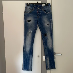 Dsquared2 byxor - Ännu ett par som har blivit för små. Sköna byxor som är riktigt snygga! På vänstra benet sitter lappen bakom hållet lite löst. Men det kan man bara sy på snabbt annars bra skick!