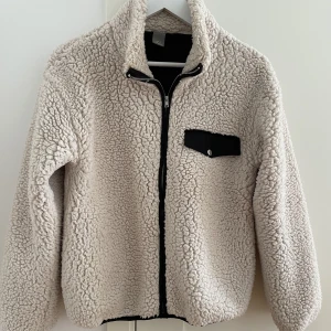 Fluffig jacka/fleecetröja  - Säljer min beiga fleecetröja/jacka från Lindex. Nyskick, använd ett fåtal gånger. Storlek S.