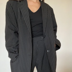 Kavaj och shorts - Svart med vita ränder. Oversized kavaj och shorts i storlek S. Använd en gång men inga synliga tecken på användning.   