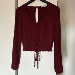 Vinröd topp - Vinröd topp/blus med snörning nedtill ❤️jätte fint skick! Storlek M men skulle säga att den är mer som S