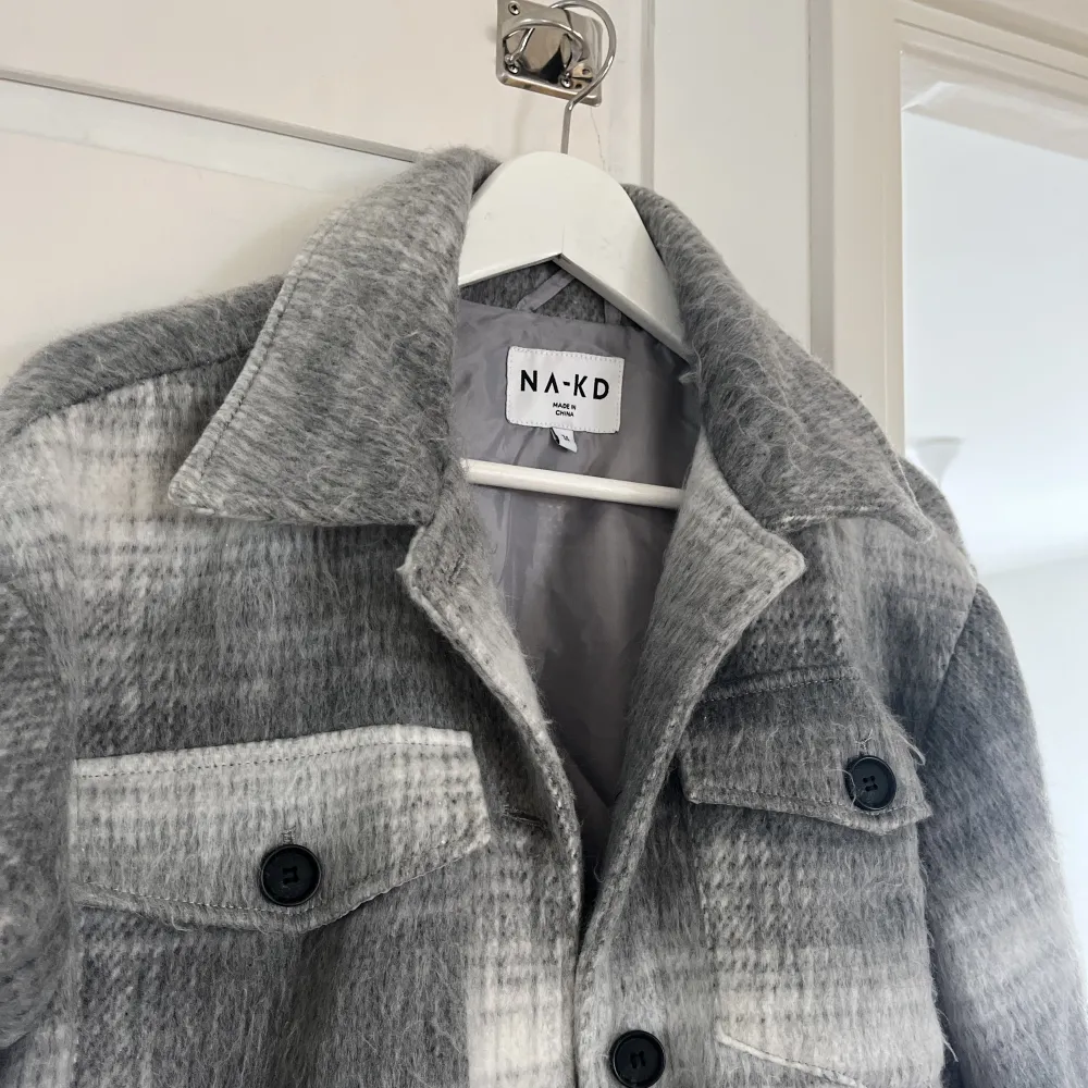Säljer denna kappa från NA-KD med coolt grå-vitt mönster 🤍🖤 väl använd men fortfarande i fint skick 🫶🏼 skriv privat för bilder av hur den sitter på!! . Jackor.