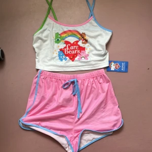 Care bear pyjamas set - Super gullig och har aldrig använts. Helt fläckfri och är super gullig. Banden i midjan är på sudda så det går ej att ändra storleken på. Klicka på köp om du vill köpa, kontakta om du har frågor!