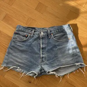 Jeansshorts från levi’s i en blå tvätt.  I modellen 501 och jeansstorlek w. 33 och l. 32. De sitter normalt i storleken. Knappar vid gylfen. 