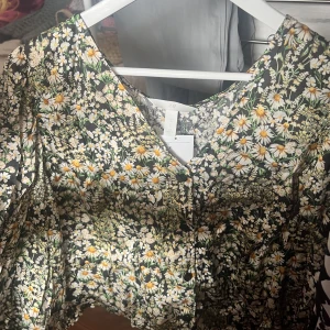 Fin blommig blus. - Blommig, sval, oanvänd blus. Storlek :XL (Katt finns i hemmet)