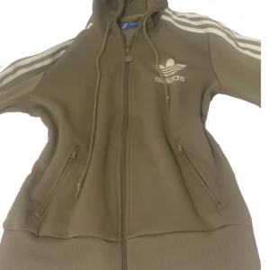 Adidas kofta  - Adidas kofta i färgen militär/oliv grön. Den är i jätte bra skick och knappt kommit till andväning.💚