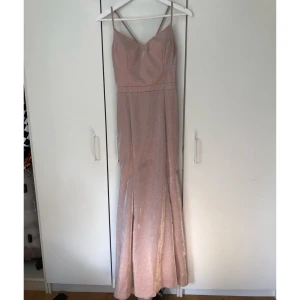 Balklänning / festklänning  - En rosa glittrig balklänning som passar både XS och S✨ Använd en gång av den förra ägaren. Säljer pga att det inte var min färg. Klänningen har en liten slits på vänster ben Finns även lite skador och missfärgning på insidan klänning (skriv för bild)