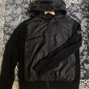 Canada goose Windbride Hoody black label M - Jackan är storlek M men väldigt flexibel i storlekarna. Den är i extremt bra skick och har precis fyllt ett år gammal. Orginalpris ligger på 6 000kr och jag söker 3000 för den. Skriv ifall du vill ha fler bilder