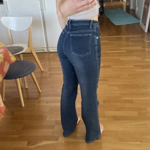 Utsvänga jeans  - Utsvänga jeans med fina pärlor som detaljer på både fickor och sidorna. Några pärlor har ramlat av.