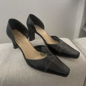 Svarta klackar med vita sömmar köpte secondhand i storlek 37. Sulan inuti skorna lossnar (se bild 2+3) men utvändigt är skorna i superbra skick. 
