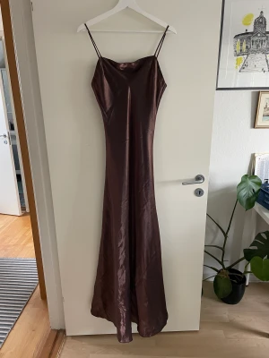 Långklänning  - Brun skimrig långklänning, passar perfekt till en bal ex. Väldigt enkel, inte uppsydd nertill.