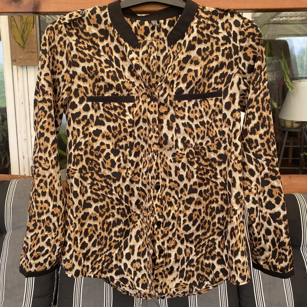 En skjorta med leopardmönster, har detaljer på axlarna se bild två. . Skjortor.