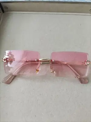 Oanvända rosa rimless solglasögon.
