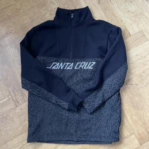 Sweater - Santa Cruz - Supersnygg och unik sweatshirt med half-zip från märket Santa Cruz.  Herrmodell men liten i storleken så passar de flesta beroende på vilket passform man är ute efter.  Först till kvarn! Väldigt unikt från en äldre & begränsad kollektion!