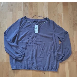 Blus - Helt ny blus från KappAhl i storlek M, nypris 299kr. Grå-lila färg. Kan fraktas men köparen står för frakten 💗