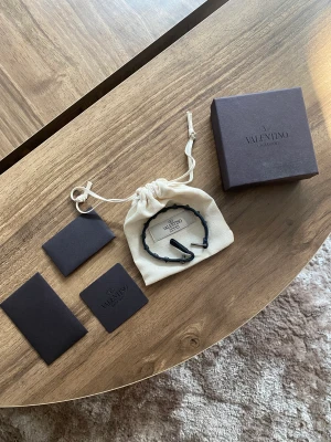 VALENTINO ARMBAND - Valentino armband av smal modell. Tycker denna modell ger ett snyggt intryck med dess lite mindre nitar. Huvudsakligen i bra skick! Mörkblå.