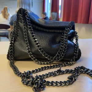 Svart väska med kedja  - Säljer min Stella McCartney likande väska jag köpte i sommars. Köpte en ny väska och använder ej denna mer!  Skriv för bilder eller frågor❤️