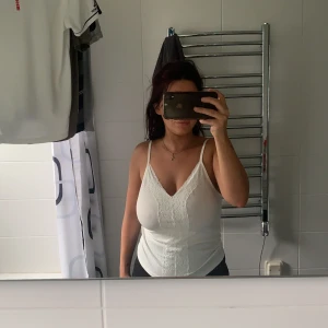 Gulligt linne.  - Linne i storlek M. Ribbad med detaljer i spets i mitten. Prislappen sitter fortfarande kvar. 