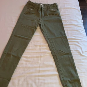 Militärgröna jeans - Gröna stretchiga jeans från KappAhl i mycket bra skick. Går att justera midjan med resårbandet visat i bild 3. Ni står för fraktkostnaden. Priset kan diskuteras.