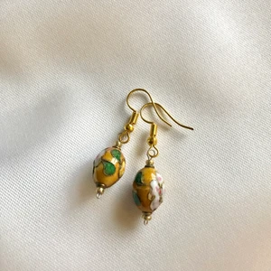 Handgjorda örhängen - Handgjorda örhängen med emaljerade gula pärlor och guldpläterade örstickare. Aldrig använda. 