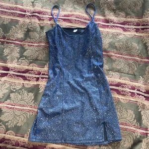 Kort glittrig klänning - En kort blå/silvrig glittrig klänning som sitter ”tajt” runt kroppen. Jättehärlig med blixt och på fest men visar, som sagt, ens kroppsform.