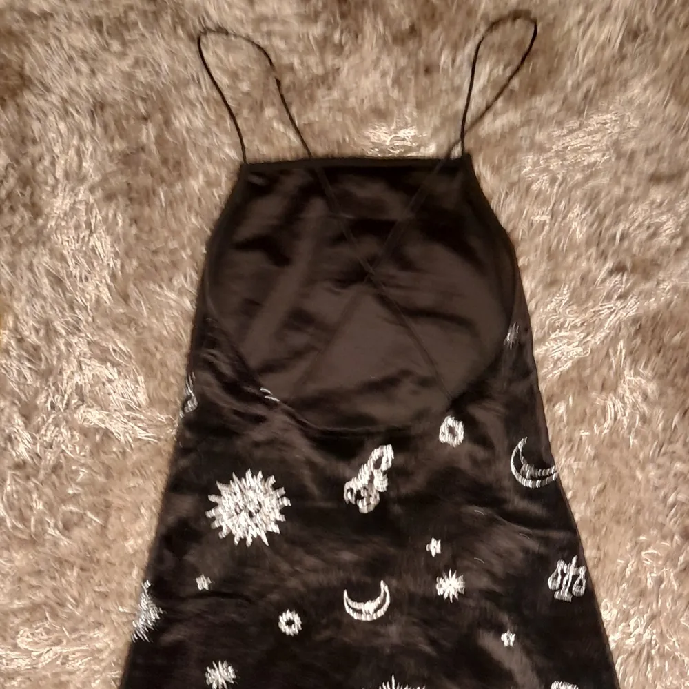 Svart tight kort klänning med glittriga stjärnmärken på. Kors I ryggen. Köpt för ca 1 år sedan, använd ca 1 gång.. Klänningar.