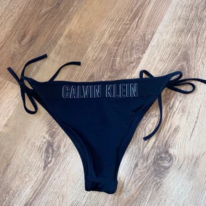 Calvin Klein Bininiunderdel stl M - Säljer ett par äkta Calvin Klein bikinitrosor i stl M. Använda fåtal gånger så extremt fint skick. Inköpta för 2 år sen på Jeansbolaget för 399 kr!
