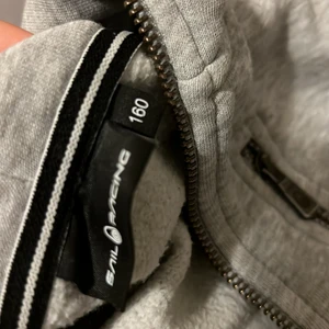 Grå sail racing kofta storlek 160 - Den är knappt andvänd och är i nyskick. Inga fläckar och inga hål. Fick som present för ett par månader sedan men den va inte riktigt min typ. För 900kr säljs samma kofta helt ny på kidsbrandstore. 600kr för nästan samma skick säljer jag den för. Pris kan dock diskuteras